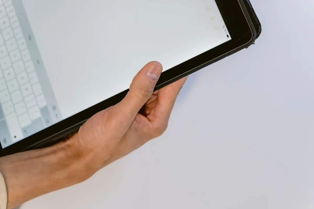 Hand houdt een tablet vast met het schermtoetsenbord open