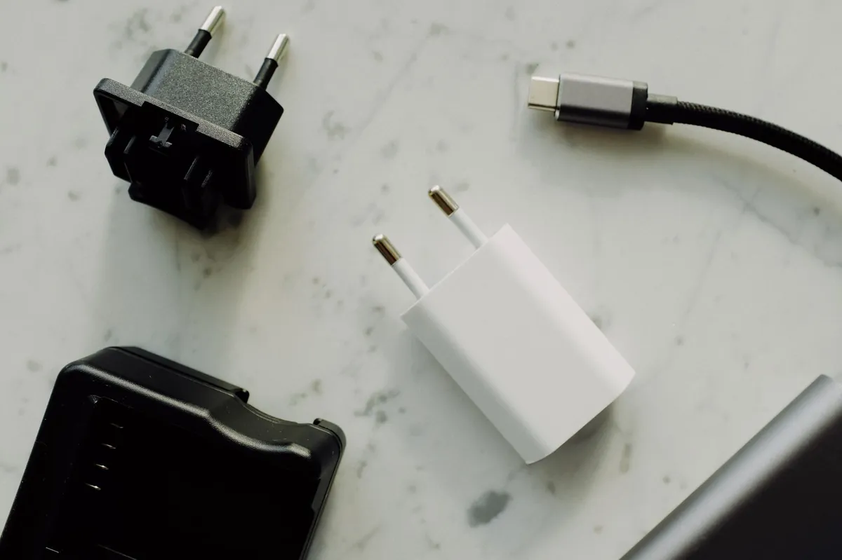 USB-C-kabel, stekkerlader en andere adapters op een marmeren ondergrond