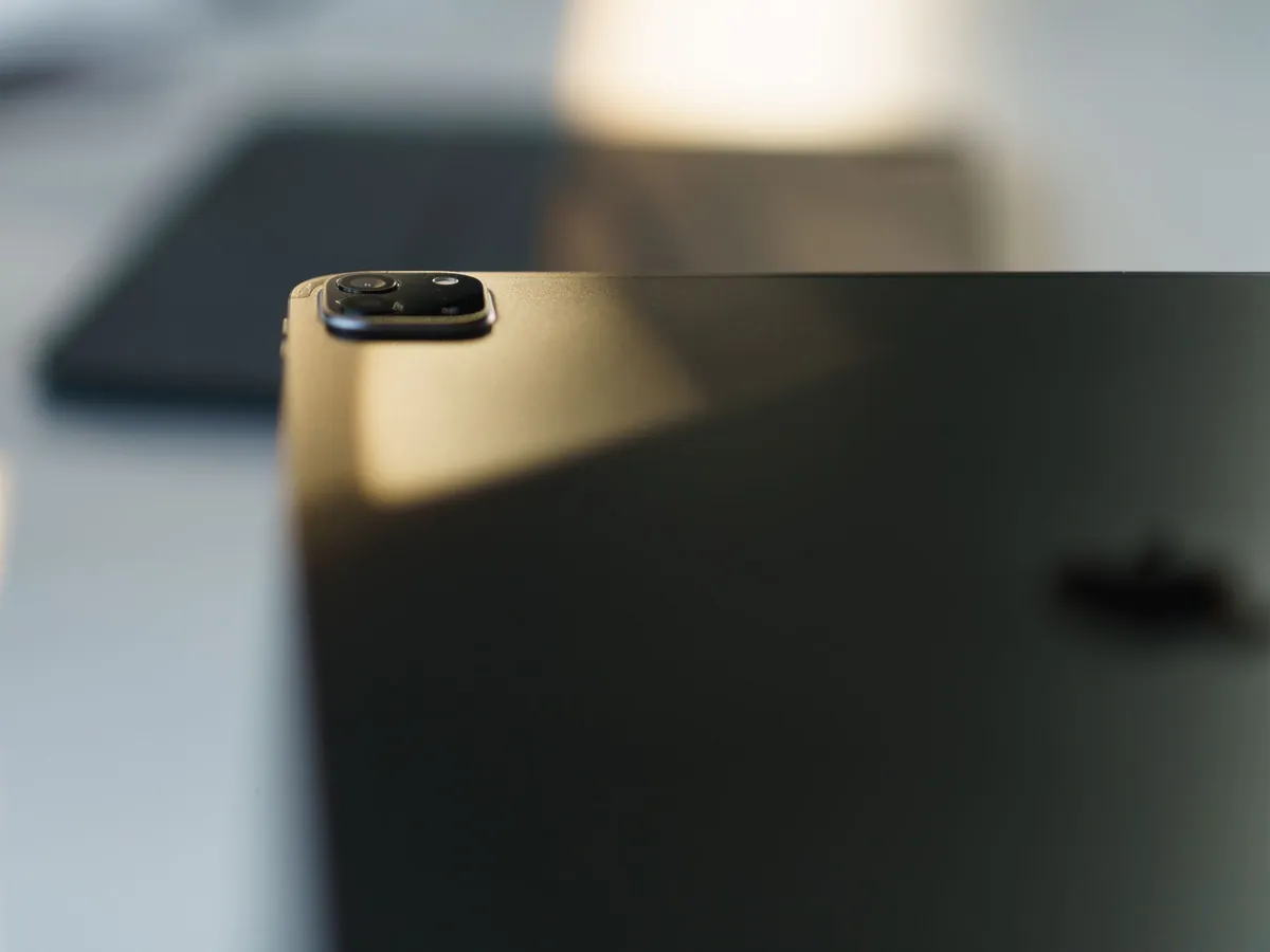 Close-up van de cameramodule op de achterkant van een donkere tablet in zacht licht