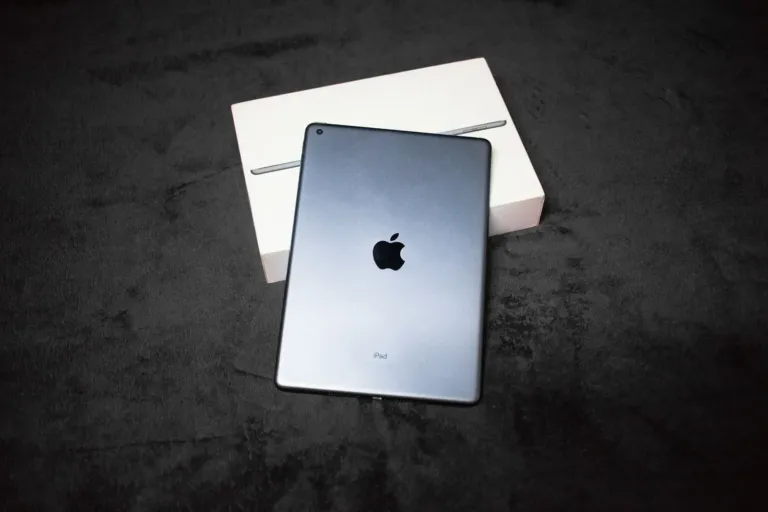 Grijze iPad liggend op een witte originele doos op een donkere ondergrond